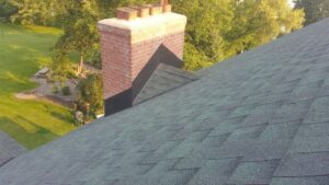 Roof flashing repair around a chimney on a residential asphalt shingle roof